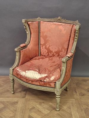 une vieille chaise dont l'assise est recouverte d'un tissu rouge