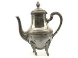 une théière ancienne en argent avec une anse, sur fond blanc