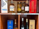 des bouteilles de vin et d'alcool sont rangées sur une étagère dans un placard