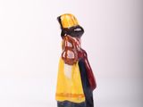 a small figurine of a woman in a yellow dress