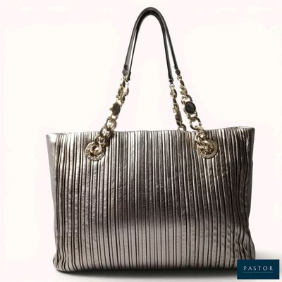 a silver purse with a gold chain hanging from the handle