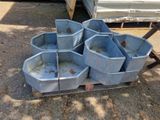 four blue buckets sitting on a pallet in the dirt