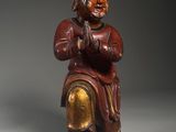 an old wooden statue of a man sitting on a chair