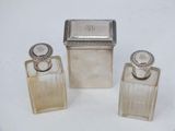 trois petits flacons de parfum en métal argenté et une petite boîte en métal argenté