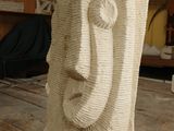 a sculpture of a face made out of rope on a wooden table