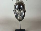 a bronze sculpture of a woman ' s head with horns on a black base