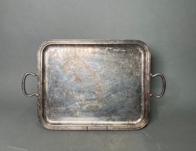 an old silver tray with handles and handles on a gray surface