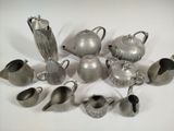 a lot of silver teapots and cups on the table