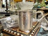 une table en verre sur laquelle est posé un vase en argent