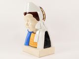 a ceramic figurine of a woman wearing a bonnet