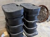 plusieurs récipients en plastique noir empilés les uns sur les autres dans une pièce