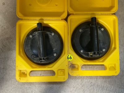 deux boîtes en plastique jaunes avec des couvercles noirs et des poignées, posées par terre