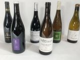several bottles of wine are lined up on a white surface