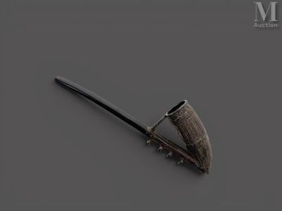 une pipe en argent avec un manche noir sur un fond gris