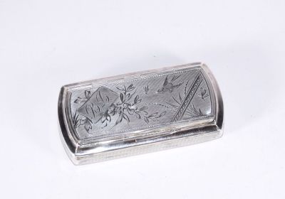 une boîte argentée ornée d'un motif sur une surface blanche