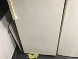 two refrigerators and a microwave in a small room