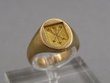 une image représentant une bague en or ornée d'une croix et de flèches