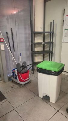 une poubelle et une serpillière dans une pièce