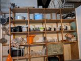 many pots and pans on the shelves in the kitchen
