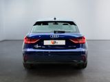 the rear end of a blue audi vehicle in a white room