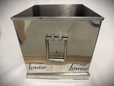 a silver metal container with a handle on a table