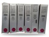 four boxes of lipstick are stacked on top of each other on a white surface