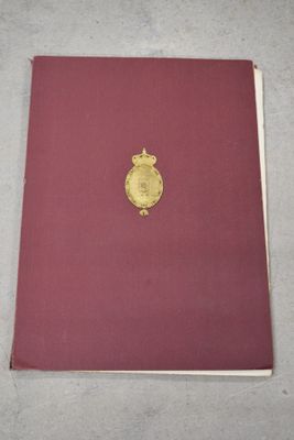 un livre rouge orné d'une médaille d'or