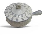 a white and blue pot with a spoon on it