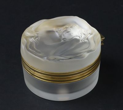 une image représentant une boîte blanche et dorée sur laquelle figure une femme