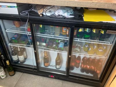a refrigerator with several bottles of beer inside of it
