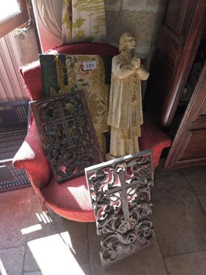 une chaise rouge dans un coin d'une pièce, sur laquelle se trouve une statue
