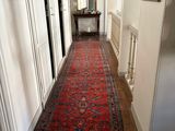 a long hallway with a red rug on the floor