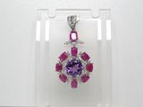 un pendentif en amethorate et saphir rose présenté dans une vitrine transparente