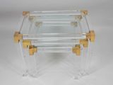 a clear glass and brass coffee table with two gold legs