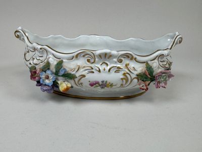 un bol blanc orné de fleurs, posé sur une table
