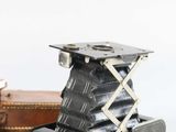 an old camera sitting on a table next to a suitcase