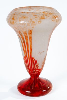 un vase en verre avec un socle rouge posé sur une surface blanche