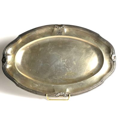 silver plate on a white surface with a handle on it