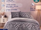 Le lit est garni d'une couette et d'oreillers gris.