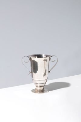 silver plated trophy cup on a white table against a gray wall