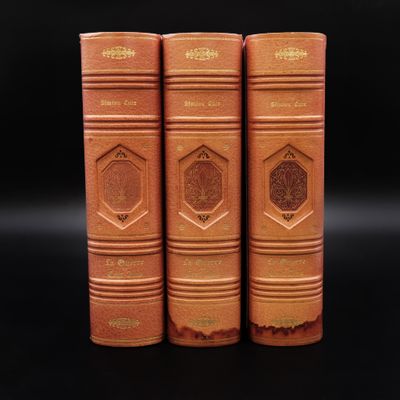 trois vieux livres empilés les uns sur les autres sur une surface noire