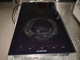 a black stove top on a metal counter in a kitchen