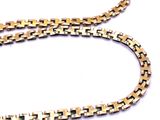 a close up of a gold chain with a cross design on it