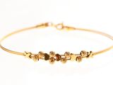 gros plan d'un bracelet en or sur fond blanc