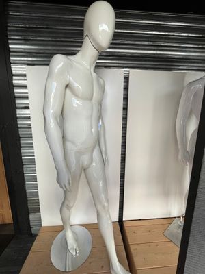 un mannequin blanc devant un miroir, dans une pièce