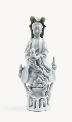 a white figurine of a woman holding a baby