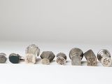 several different types of silver rings on a white surface