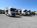 trois gros camions garés les uns à côté des autres sur un parking