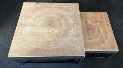 a pair of wooden tables with metal legs on a black background