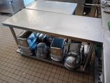 many pots and pans on a metal shelf in the kitchen
